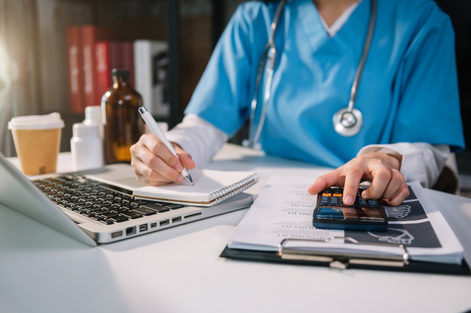 Internal medicine billing worked through with a calculator and laptop