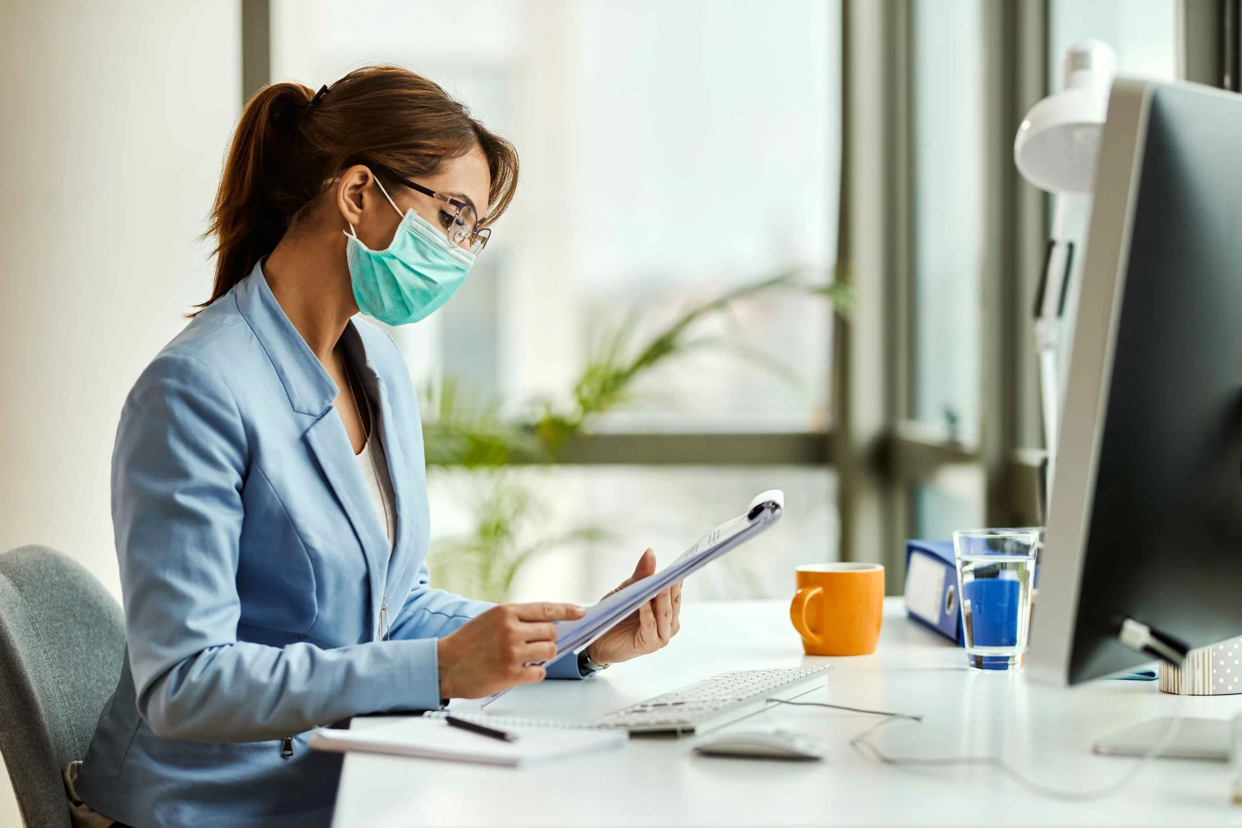Credentialing specialist reviewing payer enrolment status at a desk