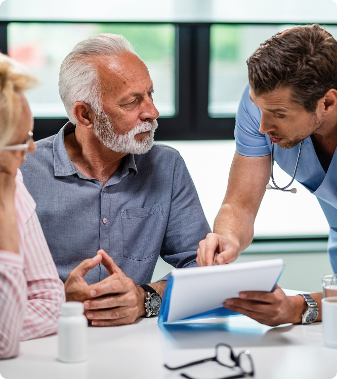 Home health nurse discussing a plan of care with an older patient and a colleague