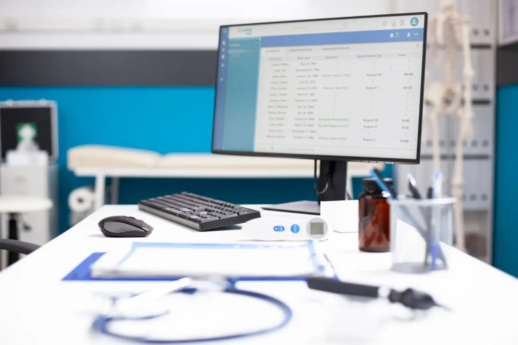 Practice management software open on a monitor at an empty clinical workstation