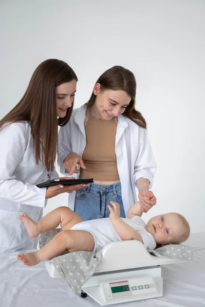 Clinicians weighing a newborn in a hospital nursery