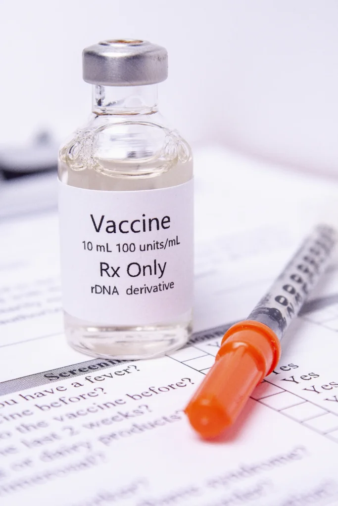 Vaccine vial and syringe on an immunization record