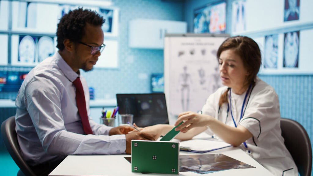 A provider and an administrator reviewing patient records together at a clinic desk