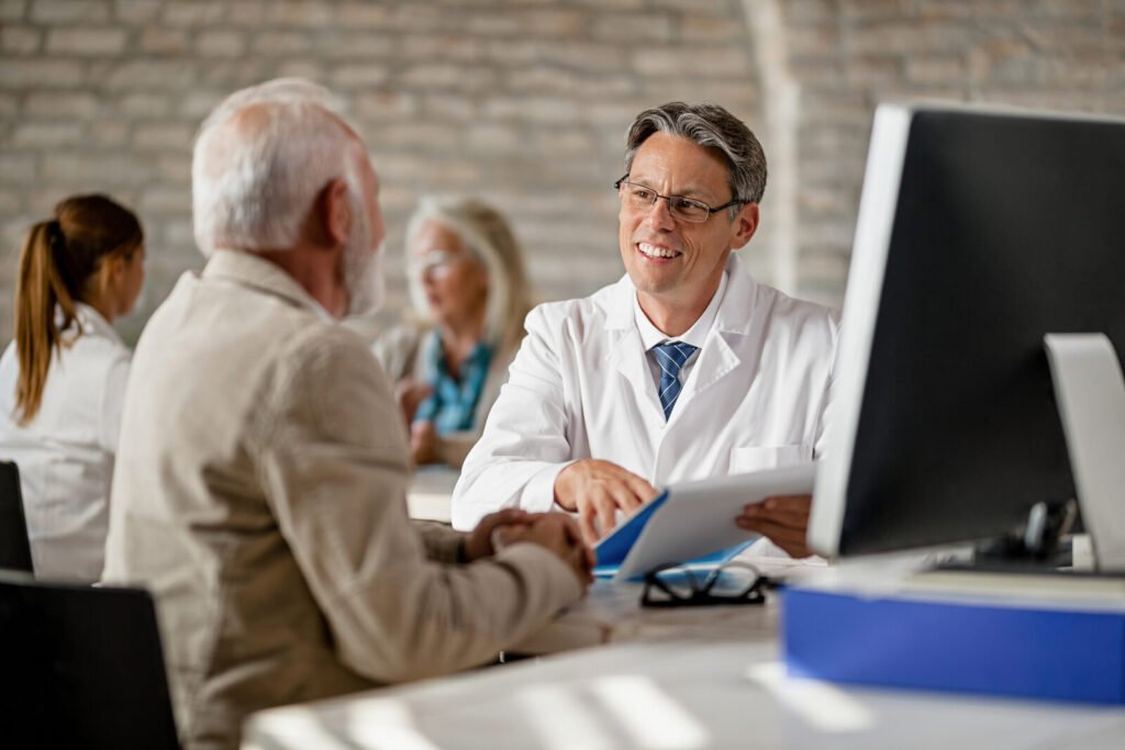 Two clinicians reviewing figures on a laptop in a bright office
