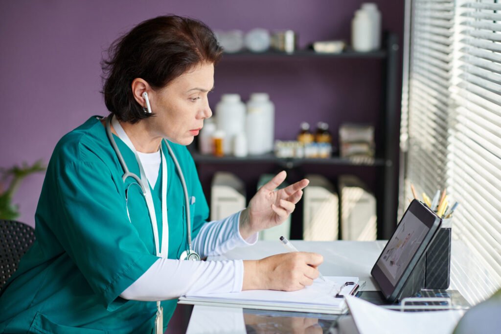 A nurse writing notes at a workstation in a clinical store room