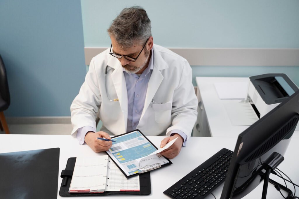 A physician reviewing a patient record on a tablet at a desk