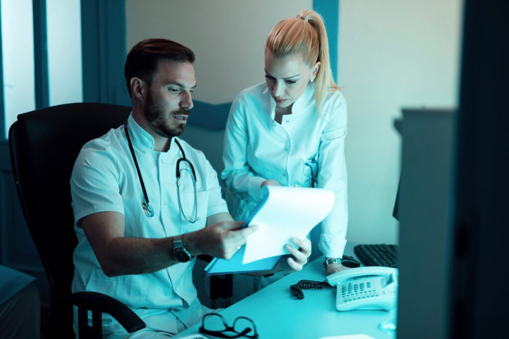 Two clinicians reviewing a document together in a treatment room