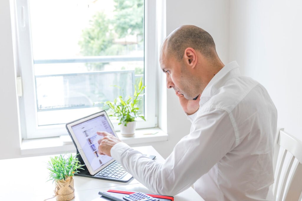 A clinician reviewing charts on a tablet by a window