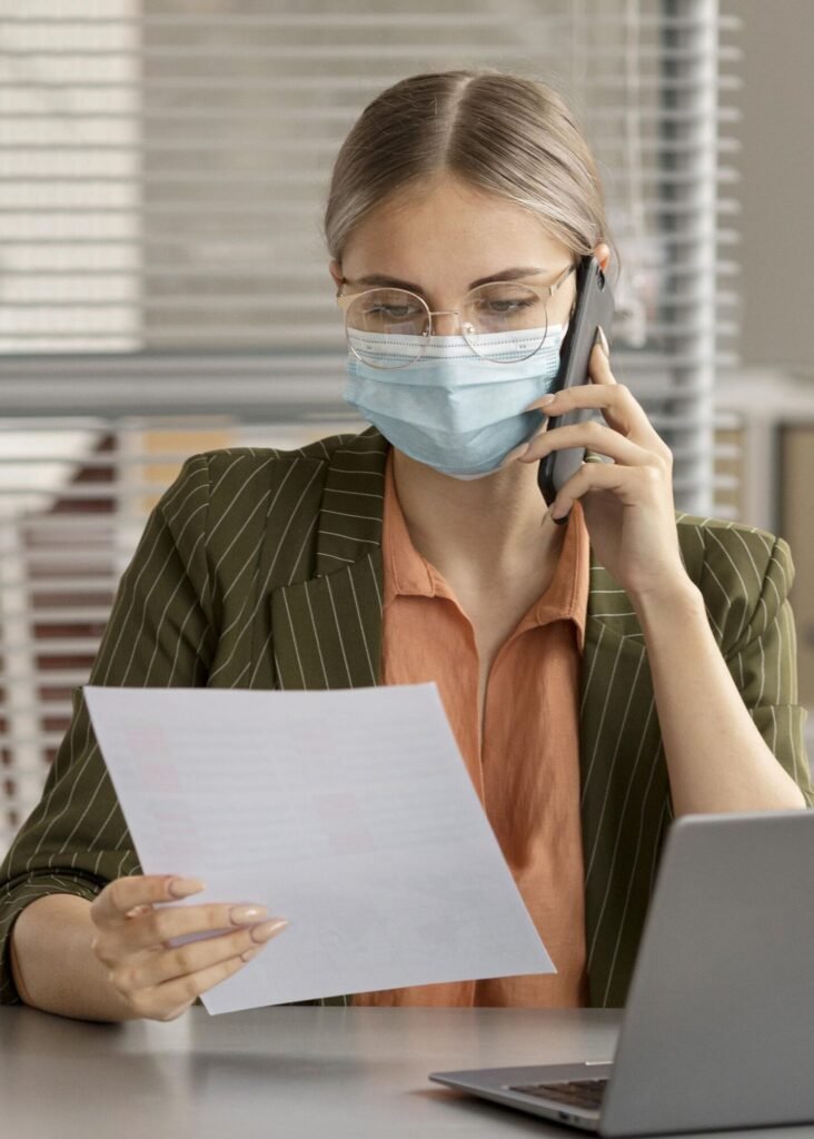 A masked staff member on a coverage call reviewing a letter