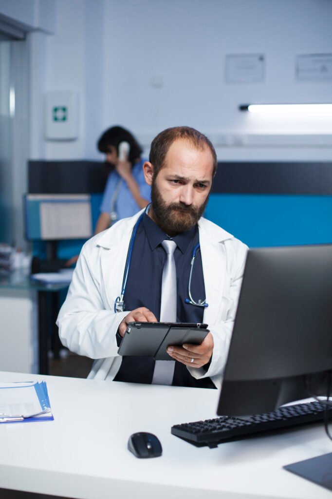 A provider reviewing information on a tablet at his workstation
