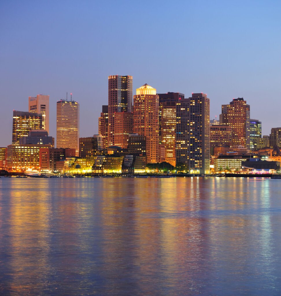The Boston skyline reflected in the harbor at dusk