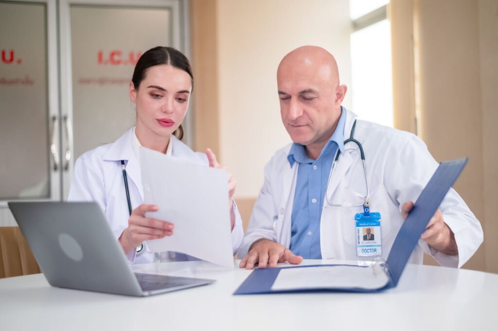 Two physicians reviewing records together at a desk