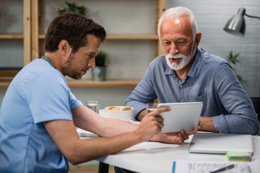 A staff member going over coverage details on a tablet with an older patient