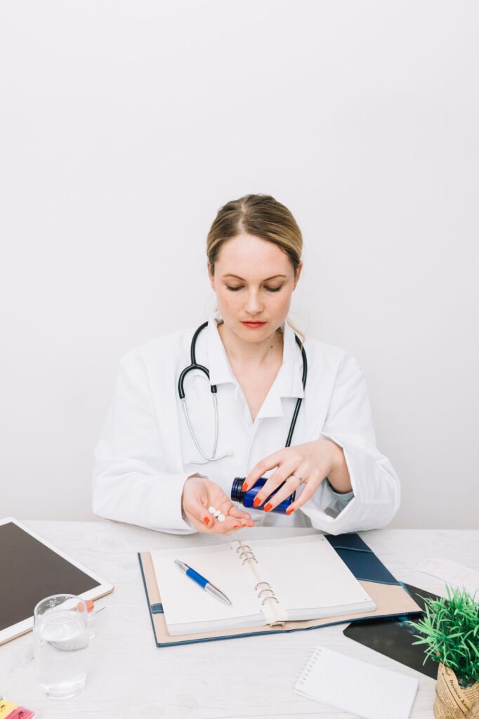 A physician writing notes at a desk beside an open file