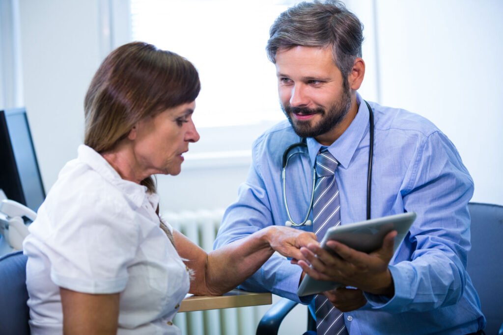A physician showing a patient information on a tablet